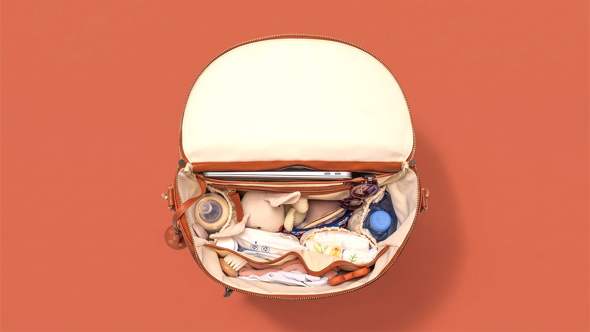 Le sac L'Iconique ouvert avec tous ces objets rangés à l'intérieur